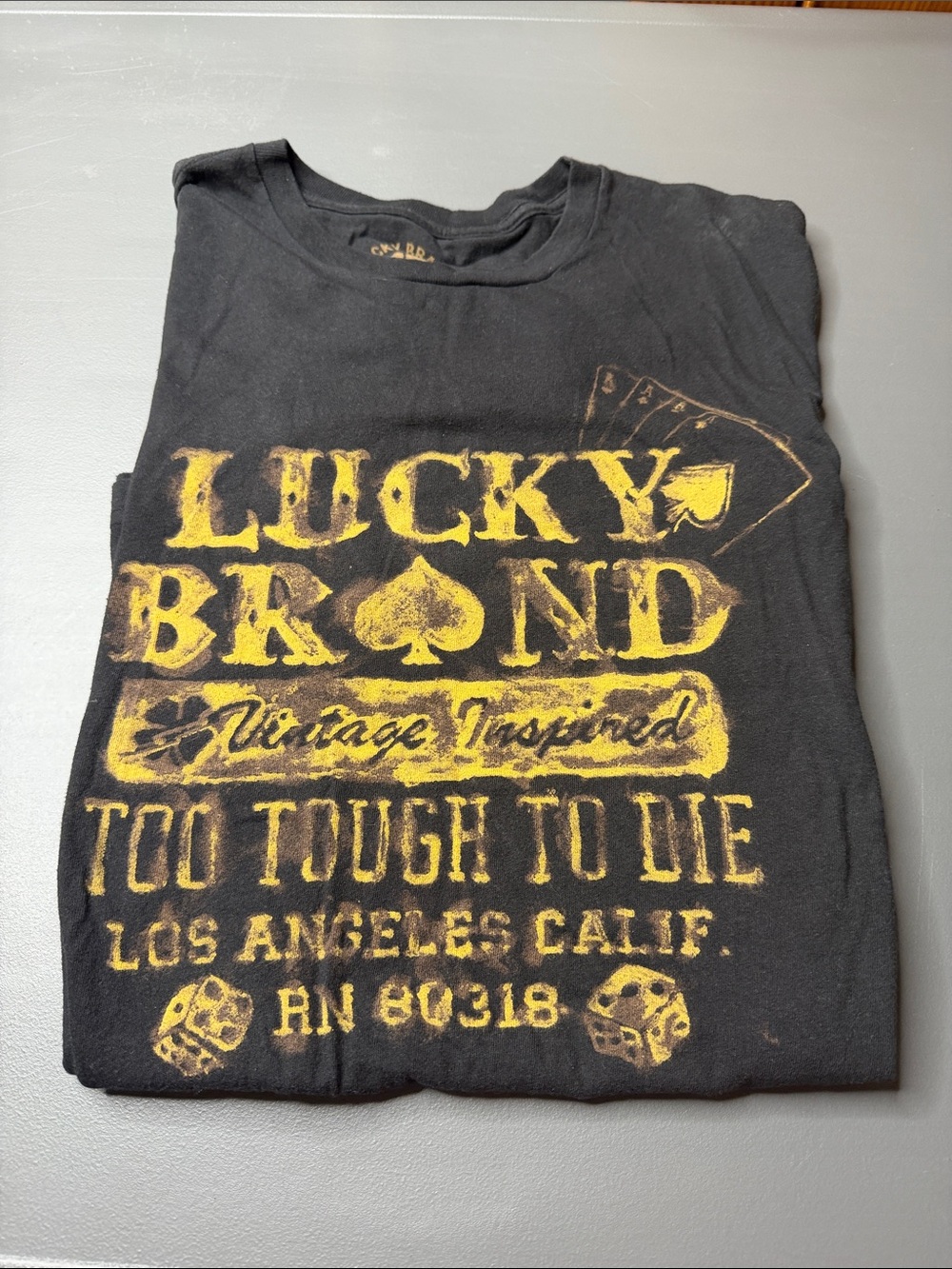 Men’s Lucky Brand Black Tee with Yellow Vintage Graphic. Size: large